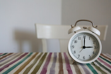 White table bell alarm clock on a colored striped base