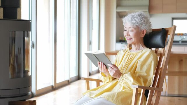室内で読書するシニア女性