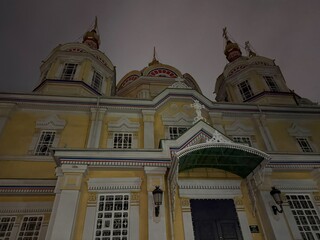 ornate orthodox cathedral in almaty with yellow neoclassical facade, red gold domes and arched...