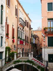 Venetian canal with historic buildings and bridge

Picturesque view of a small canal in Venice with charming pastel-colored buildings and a stone bridge, capturing the essence of Italian architecture