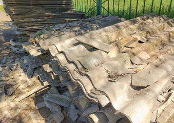Old gray slate, stacked in uneven piles and broken into pieces of different shapes and sizes....