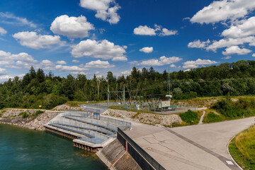Hydroelectric dam with power station and fish ladder in a scenic forest landscape under blue sky, renewable and sustainable energy infrastructure for clean power and ecological river management