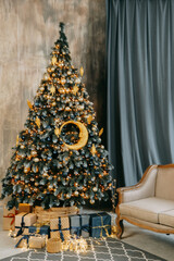 Christmas tree decorated with gold and blue ornaments. Holiday presents and string lights below for festive celebration.