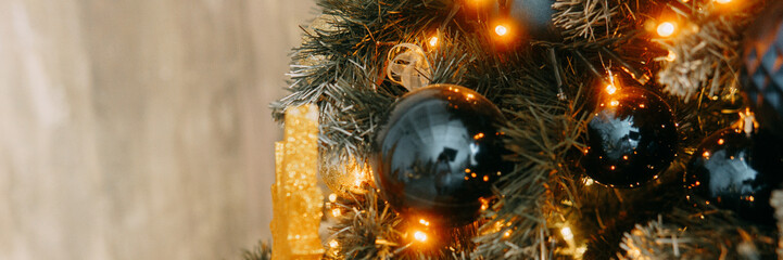 Glittering golden star ornament and dark baubles on a frosted Christmas tree. Festive holiday...