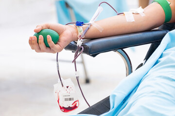 Close-up of a person donating blood in a medical clinic. A healthcare concept symbolizing altruism,...