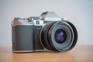 Professional camera with lens positioned on wooden surface showcasing modern design and craftsmanship