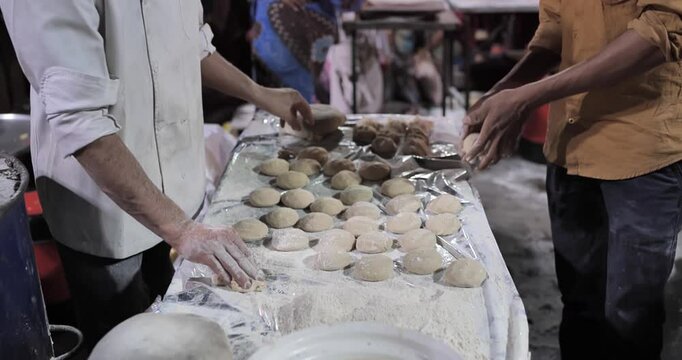Indian caterers making fresh chapatis and serving them hot in a buffet setup during a festive event