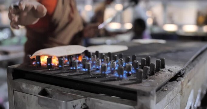 Indian caterers making fresh chapatis and serving them hot in a buffet setup during a festive event