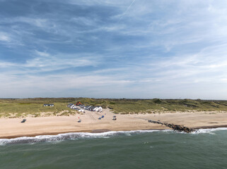 Aerial view of Stenbjerg, North Jutland, Denmark. Fishing village with classic white fishermen’s huts, sandy beaches, dunes, and the North Sea coastline, iconic summer landscape in Thy National Park