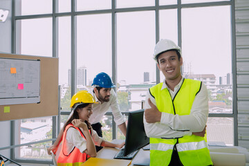 Team of professionals discussing architectural designs and site strategies using computer,...