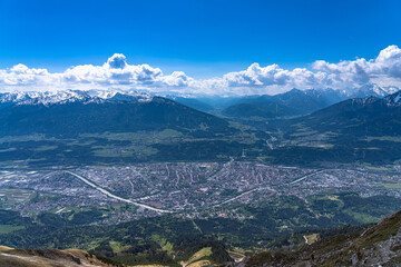 Panorama view of Innsbruck city and south Tyrolean Alps massif from Hafelekarspitze peak in spring on a sunny day, Innsbruck, Austria