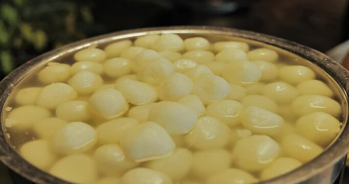 Delicious Indian sweets like laddoo, gulab jamun, dahiwada, rabadi, rasgulla, and kaju katli beautifully displayed by caterers during a festive event