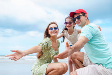Happy Family on Beach Vacation, Parents and Daughter Sharing Warm Moment and Emotional Bonding Together in Peaceful Outdoor Seaside Setting