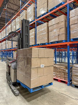 Pallet of boxes of wine on forklift in distribution centre ready for shipment.