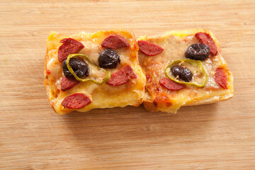 Great looking yummy pizza pieces on brown wooden bamboo cutting board