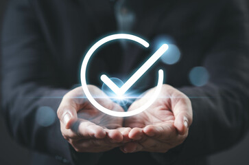 A person holds their hands up, displaying a glowing check mark symbol, representing approval or success in a professional context.