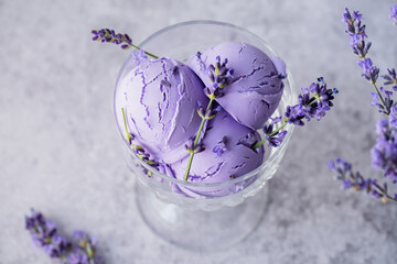 Creamy lavender ice cream presented in a clear glass dish on a gray background. Healthy dessert frozen. Sweet vegan breakfast. top view
