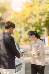 Male insurance agent inspects damaged car after accident and submits claim documents from insurance concept name selling