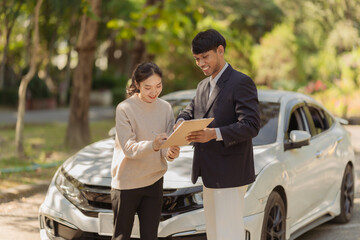 Male insurance agent inspects damaged car after accident and submits claim documents from insurance concept name selling
