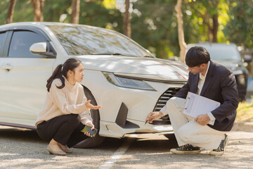 Male insurance agent inspects damaged car after accident and submits claim documents from insurance concept name selling
