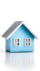 Small light blue model house with white trim windows and a gray roof on a white background