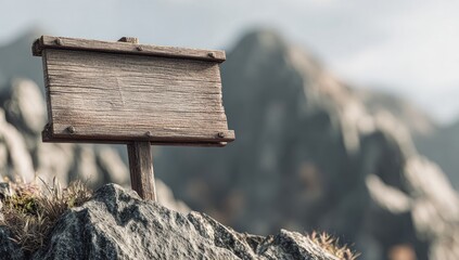 Rustic weathered wooden signpost, blank, affixed to a rocky outcrop against a blurred mountainous backdrop