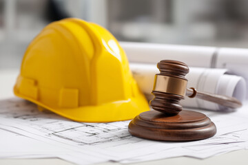 Construction law concept with gavel, blueprint, and helmet