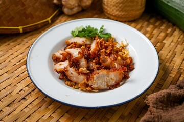 Deep Fried pork belly with garlic in white plate, asian kitchen background