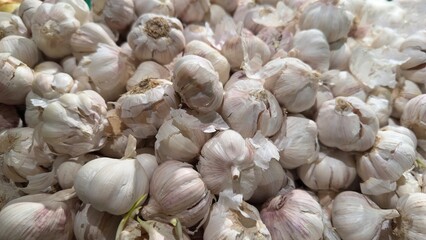 Fresh white garlic bulbs with pinkish hues in abundance — natural spice at a farmers market for healthy lifestyle and gastronomy
