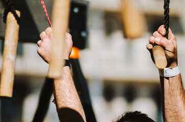 an athlete's powerful hands tackling a monkey bar or peg board obstacle