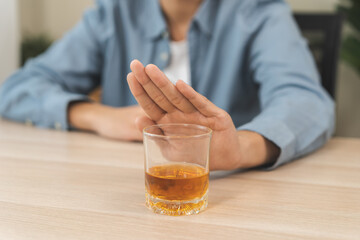 Alcoholism, depressed asian young man refuse, push out alcoholic beverage glass, drink whiskey,...