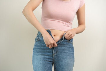 Fat belly, chubby asian young woman trying to zip it up tight jeans, obese girl excess fat around...