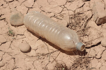 A close-up of a plastic bottle lying on the ground