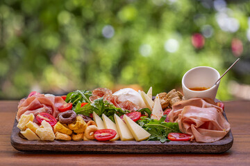 Italian Antipasto Platter with Cured Meats, Cheese, Arugula, Tomatoes, and Honey