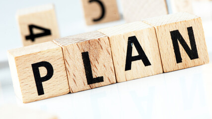 PLAN word arranged with wooden letters on a white background.