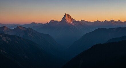 Majestic mountain peak bathed in golden sunrise light, surrounded by a vast range of dark, misty mountains.