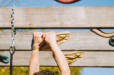 a man training for a ninja warrior competition on a wooden rig
