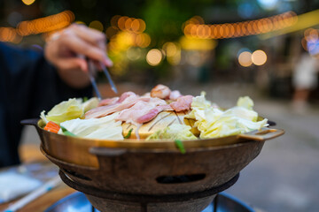 Person cooking on brass pan,barbecue grill and vegetable, street buffet thai style