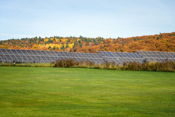 Fenced solar power plant in a forest mountain a landscape in autumn
