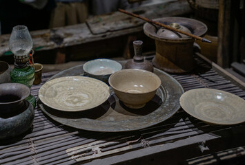A rustic setting with a collection of vintage kitchenware including ceramic bowls and plates