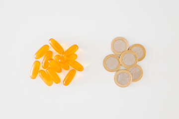 Heaps of fish oil capsule or d vitamin and euro coins on light gray table background. Closeup....