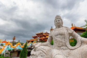 Majestic stone statue at chinese temple with dramatic sky
