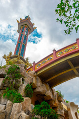 Fototapeta premium Ornate asian architectural structure with vibrant details and cloudy sky background