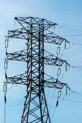 High voltage transmission tower against clear blue sky