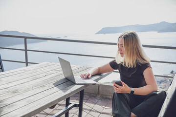 Obraz premium Remote Work,digital nomad enjoys remote work with a laptop in a scenic mountain setting.freedom of location-independent work, online business, and the balance of work and travel.