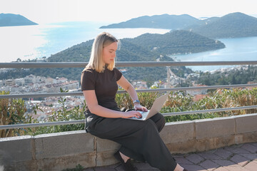 Remote Work,digital nomad enjoys remote work with a laptop in a scenic mountain setting.freedom of location-independent work, online business, and the balance of work and travel.