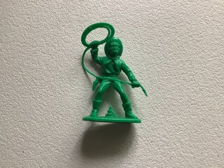 a green plastic toy cowboy