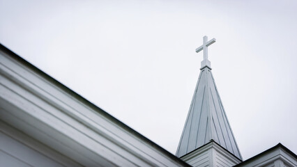 cross on the roof of the church, a white-painted church steeple and cross
