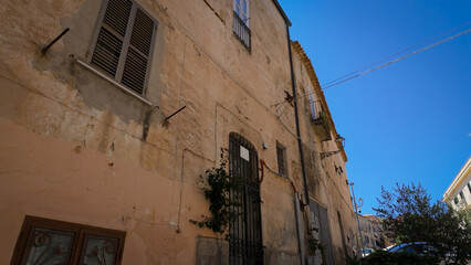 Traditional Italian architecture is displayed on a weathered building in Tropea, Italy, under a...