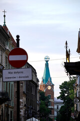 Historic street view with old buildings, traffic sign in foreground, clock tower with turquoise...